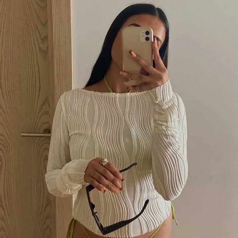 A clean, fitted crop with ruched texture and long sleeves.